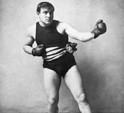 Photographie en noir et blanc d'un homme portant des gants de boxe.