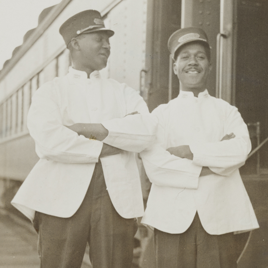 De gauche à droite : Smitty de Montréal et Albert Budd debout à côté d’un train.