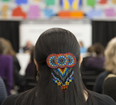 Photo couleur d'une pince à cheveux ornée de perles multicolores à l'arrière de la tête d'une femme