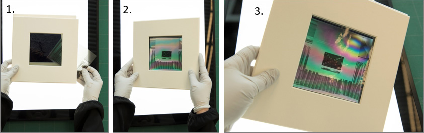 mains gantées manipulant la visionneuse polarisante avec négatif à l'intérieur tel que décrit dans les étapes 1 à 3